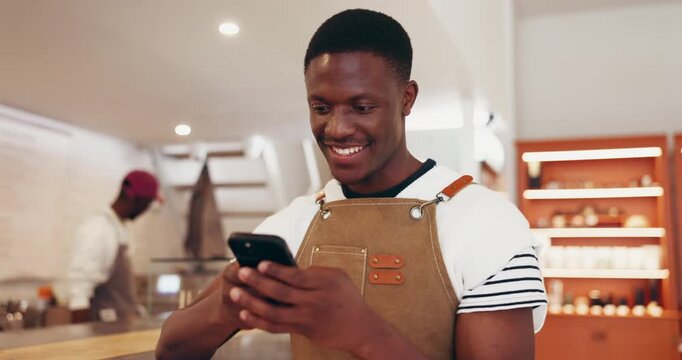Happy man, waiter or typing in cafe with phone for communication, text message or online chat. Smile, black person or employee in restaurant with tech for internet search, social media or mobile app.