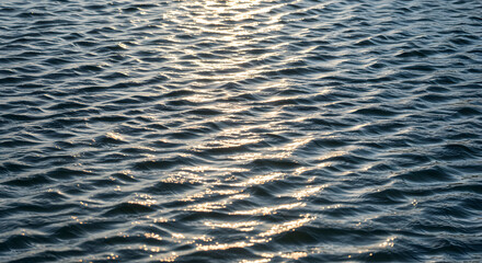 Obraz premium Rippling Water Surface Reflecting Sunlight in a Serene Outdoor Environment