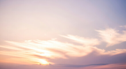 Fototapeta premium A serene sunset sky with soft, pastel hues and wispy clouds.