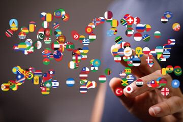 Person pointing to a collection of flags representing different countries, symbolizing global interconnectedness, unity and international relati