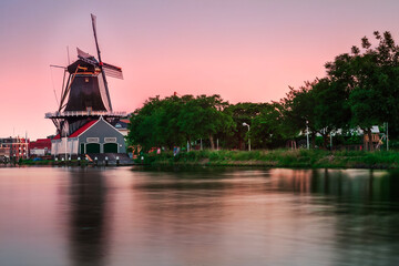 Long exposure sunset behind a 17th century sawmill on the Vliet canal, in Leidschendam, The Netherlands.