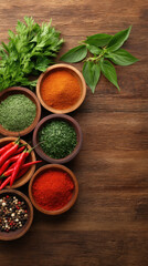 An overhead shot displays vibrant spices and fresh herbs artfully arranged in wooden bowls on a rustic wooden surface, creating an inviting culinary still life.