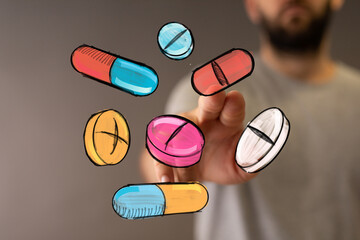 A hand interacts with colorful medication pills and capsules.  Health, medicine, pharmacy concept.