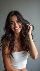 Obraz premium Joyful woman with long, wavy hair smiling brightly