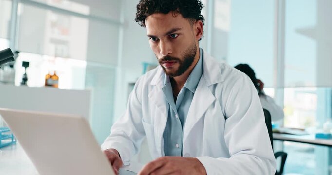 Serious, scientist and man with laptop, online or medical research on website, biotechnology or lab. Clinic, researcher and person with tech for project, typing and article for science and healthcare