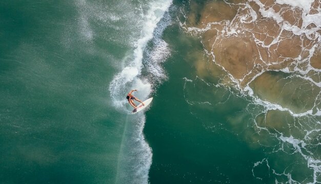 Aerial view of pro surfers on ocean waves - Powered by Adobe