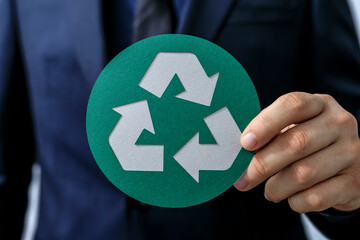 Eco-friendly business concept.  Image of a businessman holding a recycle symbol.