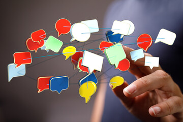 Person's hand interacting with a network of speech bubbles representing digital communication and social media connections.