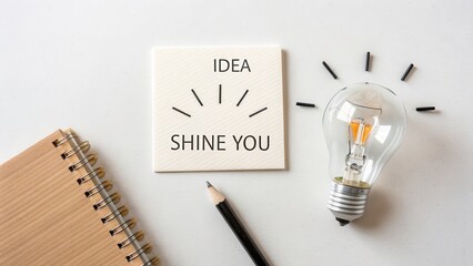 A bright lightbulb and idea concept on a white desk