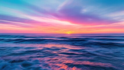 Obraz premium A breathtaking sunset over the ocean, featuring a sky ablaze with vibrant pink, purple, and orange hues reflecting on the gentle waves.