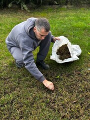 man collects weeded grass in a bag