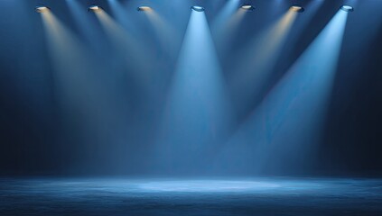 Stage lit by several spotlights casting blue beams, with a dark, textured floor and backdrop