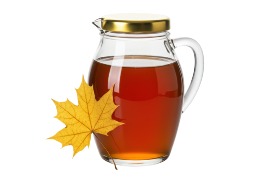 Maple syrup in glass pitcher isolated, with yellow maple leaf, sweet breakfast topping