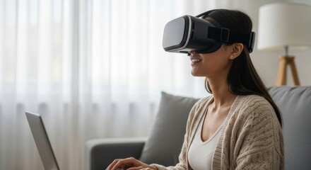 Asian female using vr headset and laptop in modern living room