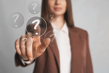 Business woman touching question mark on virtual screen against grey background, closeup