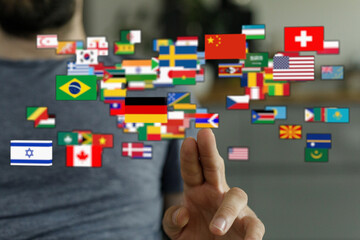 A human hand interacting with a visual representation of global flags, symbolizing international relations, travel, and diverse cultures. Global