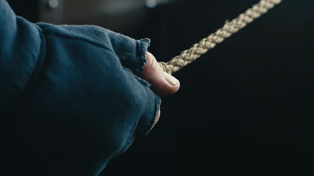 Close Up Hand Pulling Train Whistle Cord - A close-up shot of a hand in a torn glove pulling a rope, likely a train whistle cord.