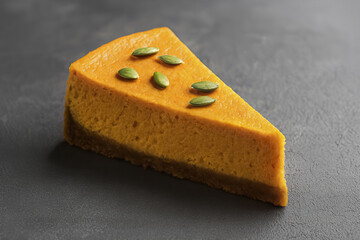 The autumn dessert is decorated with several green pumpkin seeds on top. The simple and elegant presentation highlights the seasonal treat.