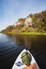 Enjoy paddleboarding on calm waters, amidst beautiful autumn cliffs. This serene experience connects you with nature, rejuvenating your spirit and offering a peaceful escape from daily stress