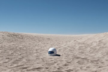 Obraz premium A Solo Safety Helmet Resting in a Vast Empty Expanse Under a Clear Blue Sky