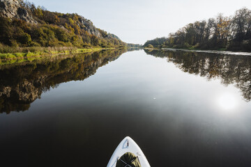 Enjoy the calming joy of paddleboarding on a tranquil river surrounded by vibrant nature, a perfect escape into the outdoors where peace and leisure await at every turn and paddle stroke