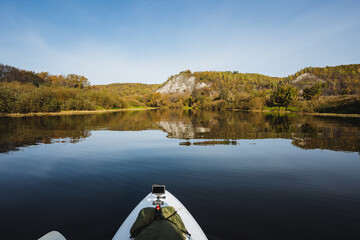 Autumns beauty radiates in a tranquil lake surrounded by vibrant greenery and majestic mountains, creating an ideal setting for adventure and relaxationa perfect nature getaway for all
