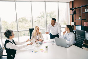 Corporate professionals collaborating in a meeting room discussing strategies with mutual engagement and focus in a modern office space