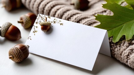 Blank greeting card with acorns and leaves on a knitted fabric, perfect for autumn celebrations or personal messages