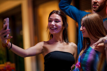 Fototapeta premium Group of smiling friends taking a selfie during social event