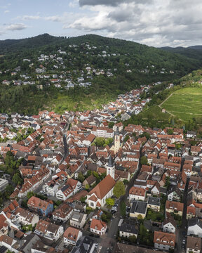 Aerial view of the quaint town nestled against the lush, verdant hillside, where terracotta roofs meet the emerald foliage, Schriesheim, Baden-Wurttemberg, Germany.