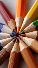 Obraz premium Colorful arrangement of pencils in a circular pattern highlighting various shades and tones in a well-lit workspace