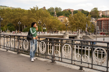 Obraz premium Young tourist enjoying ice cream on bridge in san sebastian, spain