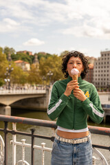 Fototapeta premium Young woman enjoying ice cream on a bridge in bilbao