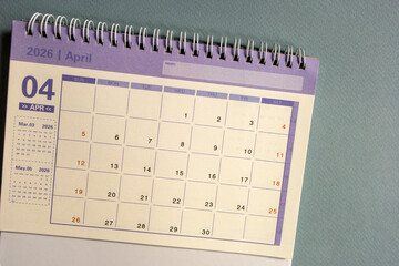 Desktop calendar for April 2026 on a gray background with a copy of the copy.