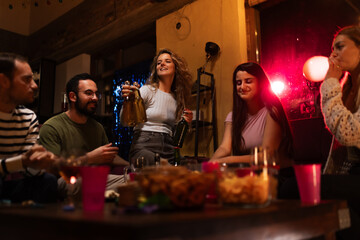 Group of Friends Enjoying a Cozy Gathering in a Warmly Lit Room
