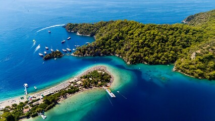 Aerial view of the Oludeniz Blue Lagoon in Fethiye, Turkey, with turquoise waters, sandy beach, forested hills, and boats, showing a popular Mediterranean travel and holiday destination. © Bulat