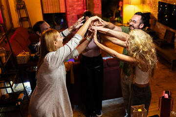 Group of cheerful friends enjoying time together in cozy home setting with warm lighting