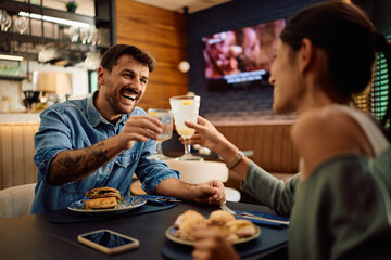 Happy couple toasting while enjoying their lunch in restaurant.