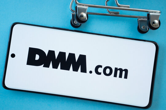 Dhaka, Bangladesh- 03 Oct 2025: Smartphone screen showing the Dmm.com logo with shopping cart wheels on a blue background.