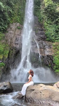 Woman enjoying nature at Gitgit waterfall in Bali , Singaraja, Indonesia