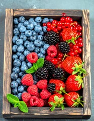 Close-up of assorted fresh berries in a rustic wooden box