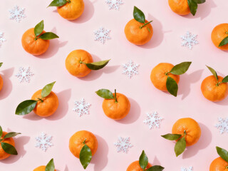 Colorful mandarin oranges arranged on a pink background with snowflakes during winter festivities