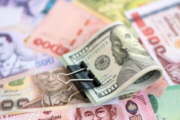 Thai baht currency money bills and bunch of us dollars. The concept of currency exchange