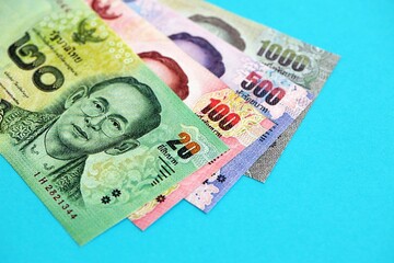 Thai baht money bills in big amount on blue. Finance and banking concept