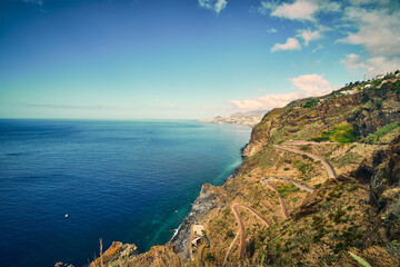 pectacular aerial view of the rugged coastline near the Cristo Rei statue in Madeira, Portugal.
