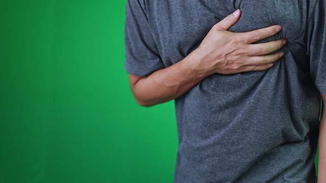 man clutching chest in pain, illustrating heart attack, chest pain, heart disease, or emergency medical condition, green screen background