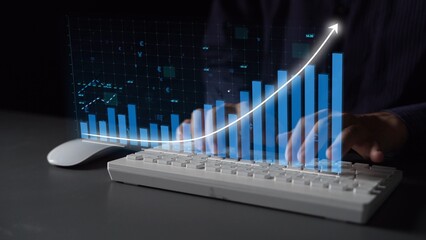A close-up view of a person hands typing on a keyboard, with a 3D graph overlay displaying financial growth trends and data analysis in a modern office environment. Copula