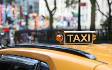 TAXI sign on top of the yellow car transporting people around