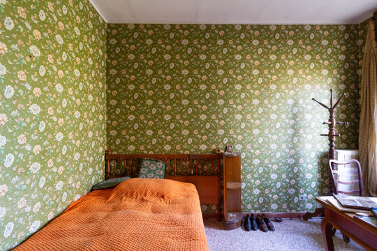 Camera da letto con copriletto e carta da parati verde