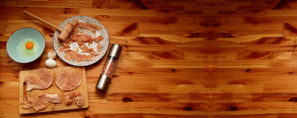 A clean, rustic top view banner of raw chicken chops ready for cooking. raw chicken chops or cutlets on a wooden background. top view healthy meal preparation lifestyle
